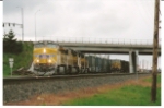 UP 7827 goes under the 10th St. bridge as she rolls south with a manifest train.